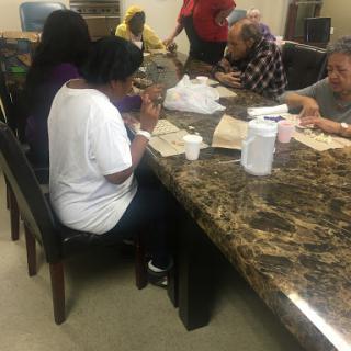 A group of people gathered around a table, engaging in activities together.