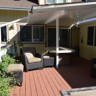A cozy outdoor patio with wicker furniture and a covered deck.