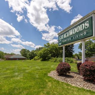 A scenic view of a park with a sign reading 'Lakewoods Senior Living'.