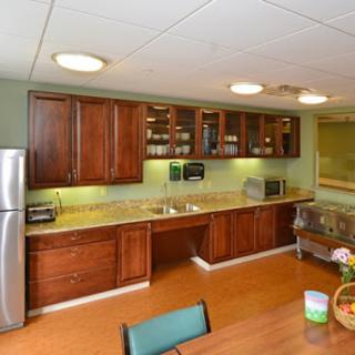 A modern kitchen featuring wooden cabinets, stainless steel appliances, and a well-lit countertop.
