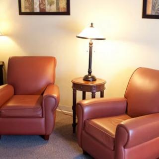 A cozy living room with two red armchairs and a lamp on a side table.
