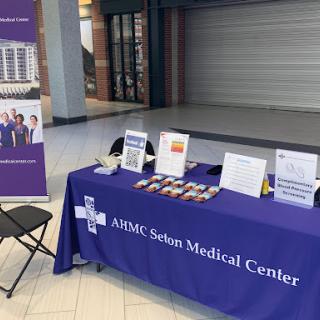 Information booth for ASMC Salin Medical Center showcasing healthcare services and resources.