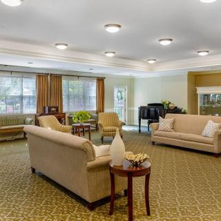 A spacious and well-lit living room with elegant furniture and a piano.