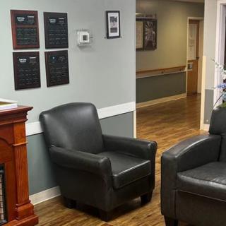 A cozy waiting room with leather chairs and a wooden floor.