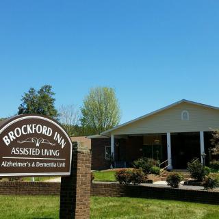 A sunny day at Brockford Inn Assisted Living with a clear view of the building and its sign.