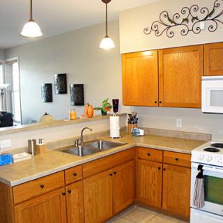 A bright and modern kitchen featuring wooden cabinets, a clean countertop, and ample lighting.