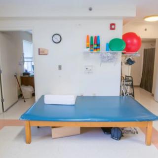 A physical therapy room equipped with a therapy table and exercise equipment.