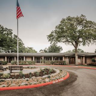 A welcoming community center featuring an American flag and landscaped surroundings.