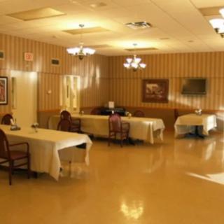 A well-lit dining room with tables and chairs arranged for guests.