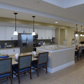 A modern kitchen with a dining area featuring counter seating and elegant lighting.