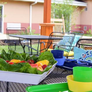 A vibrant outdoor patio setup with a fresh salad and colorful dishes.