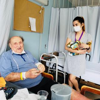 A patient receiving care from a nurse in a hospital room.