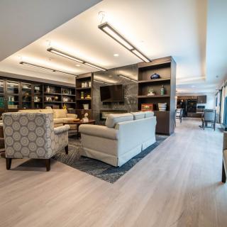 Modern living room with comfortable seating and extensive bookshelves.