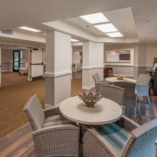 A cozy lounge area with tables and chairs under soft lighting.