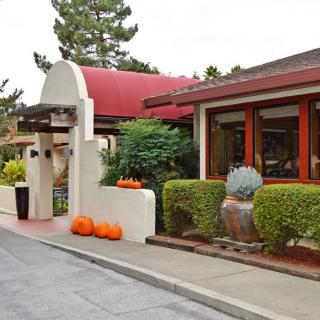 Entrance to a restaurant adorned with seasonal pumpkins and lush greenery.