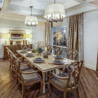 A beautifully decorated dining room with an elegant wooden table set for a meal.