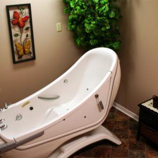 A modern spa bathtub in a warmly decorated bathroom.