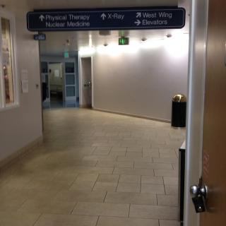 A hospital hallway with directional signage overhead.
