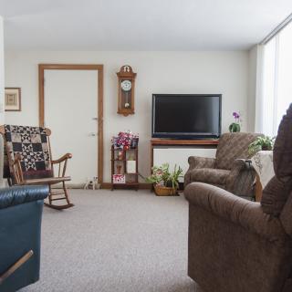 A cozy living room with a television, rocking chair, and comfortable seating.