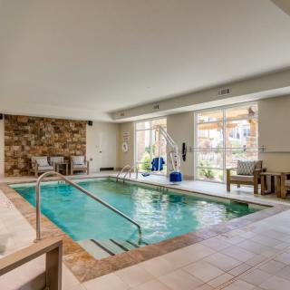 A luxurious indoor pool area with natural light and modern furnishings.