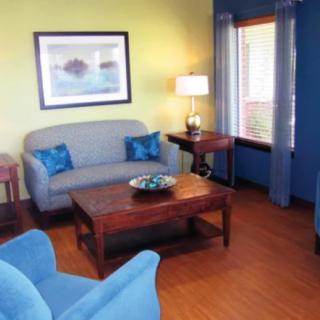A cozy living room with blue furniture and a wooden floor.
