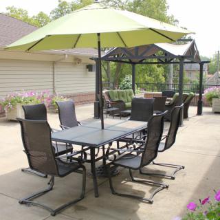 An outdoor patio area with furniture, including a table, chairs, and an umbrella.