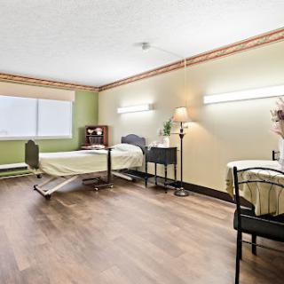 A clean and well-lit hospital patient room, featuring a bed, bedside table, and comfortable furnishings.