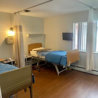 A well-lit hospital room featuring two patient beds, designed for comfort and care.