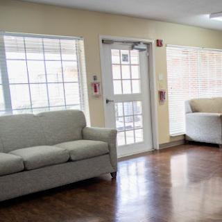 A cozy seating area in a well-lit lobby, featuring a soft sofa and armchair.