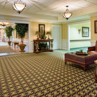 A well-decorated hotel lobby featuring plush carpeting, elegant chandeliers, and comfortable seating.