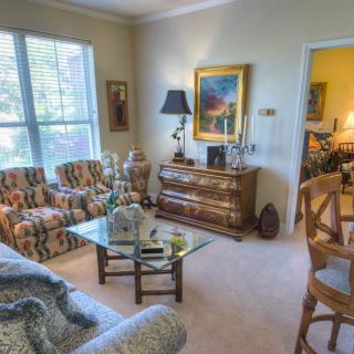 A cozy living room with colorful furniture and decorative elements.
