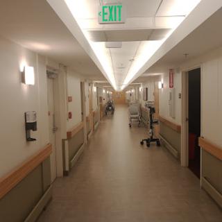 A quiet and well-lit hospital hallway, showcasing the sterile environment typical of medical facilities.