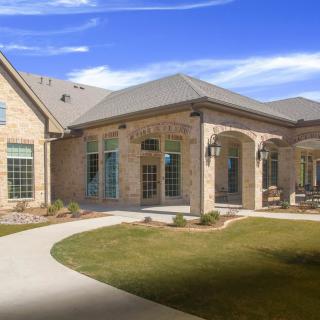 A modern brick house with a well-maintained lawn and pathway.