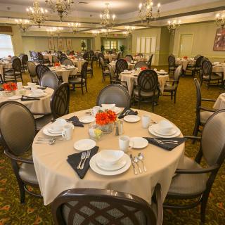 An elegant dining room with tables set for a formal meal.