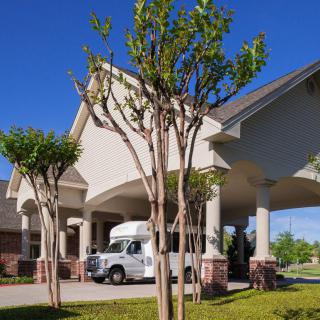 A residential building entrance with a van parked under an archway.