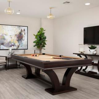 A modern game room featuring a stylish pool table, contemporary artwork, and sleek interior design elements.