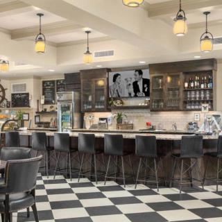 A modern cafe with checkered flooring and a sleek bar area.