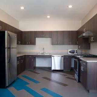 A modern kitchen featuring sleek cabinetry, stainless steel appliances, and a unique floor design.