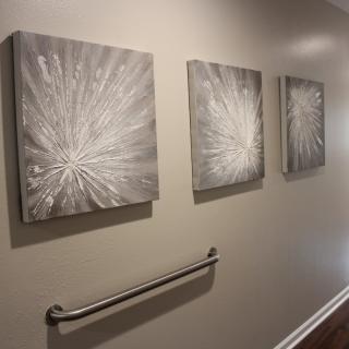 Abstract monochrome paintings displayed in a hallway.