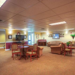 A cozy living area with sofas, tables, chairs, and a television.