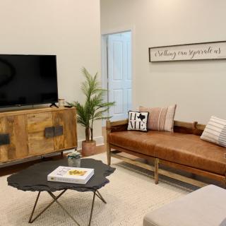 A cozy, modern living room with minimalist decor featuring a leather sofa, wooden cabinet, and stylish coffee table.