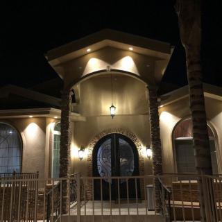 A well-lit house exterior at night, showcasing its architectural design.