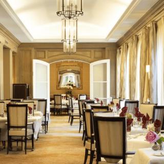 An elegant and luxurious dining room with beautifully set tables and chandeliers.