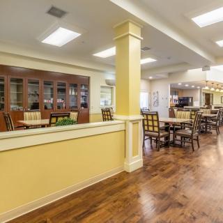 A spacious dining area featuring wood flooring and comfortable seating arrangements.