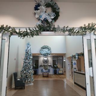 A beautifully decorated lobby featuring a Christmas tree and festive wreath.