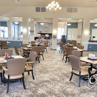 A spacious and elegantly designed dining room featuring modern furniture and ample natural light.