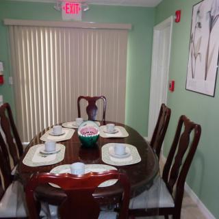 A dining room with a set table and green walls.