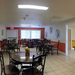 A spacious dining area with multiple tables and chairs arranged neatly.