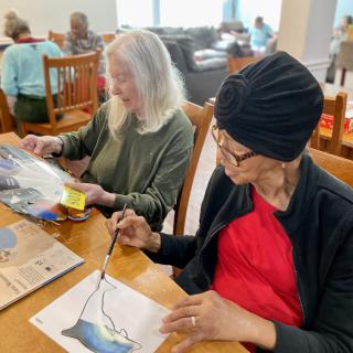 Seniors engaged in an art class, painting and enjoying community activities.