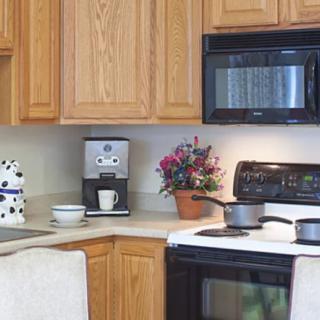 A cozy kitchen corner featuring various appliances and wooden cabinetry.